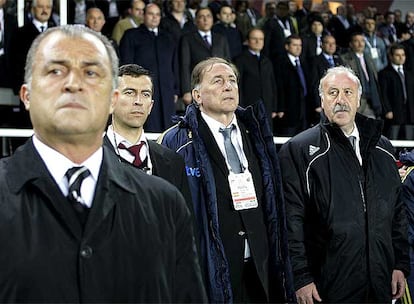 En primer plano, a la izquierda, el rostro rígido del seleccionador turco, Fetih Terim, quien ha sido vinculado en los últimos días al Sevilla. A la derecha, su homólog Vicente del Bosque antes del inicio del partido.