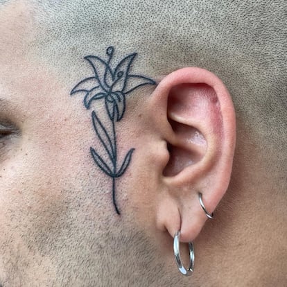 Imagen cedida por el tatuador Álvaro Costa, más conocido como Cos.915, de una flor tatuada al lado de la oreja: una de las formas más sencillas de iniciarse en el tatuaje facial.