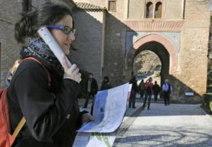 Una turista escucha un audioguía en el conjunto de la Alhambra en Granada.EFE/Archivo