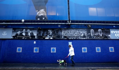 Una mujer pasea delante del Goodison Park, en Liverpool, estadio del Everton FC que será sustituido por el nuevo Everton Stadium, aún en construcción