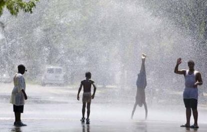 Un grupo de niños juega bajo el agua lanzada por una boca de incendios abierta por las autoridades de la ciudad de Chicago para aliviar el calor.