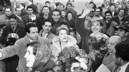 Enrique Herreros hijo, con el brazo, abre camino entre el gentío a Romy Schneider el 15 de enero de 1957 a su llegada al aeropuerto de Barajas para promocionar 'Sissi'. A la derecha, con la caja de la distribuidora Dipenfa, Enrique Herreros padre.