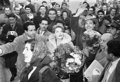 Enrique Herreros hijo, con el brazo, abre camino entre el gentío a Romy Schneider el 15 de enero de 1957 a su llegada al aeropuerto de Barajas para promocionar 'Sissi'. A la derecha, con la caja de la distribuidora Dipenfa, Enrique Herreros padre.