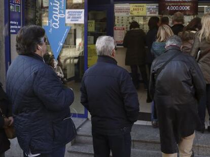 Vista de las colas de personas delante de la administración de loteria situada en el Paseo de la Esperanza, número 4, en Madrid.