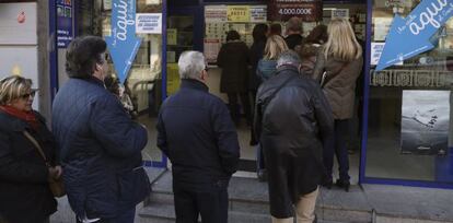 Vista de las colas de personas delante de la administración de loteria situada en el Paseo de la Esperanza, número 4, en Madrid.