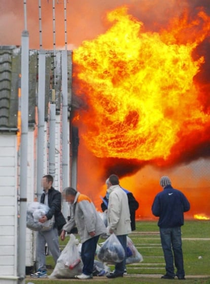 Unos presos escapan de sus módulos, que se consumen por un incendio provocado por unos cuarenta reclusos de la prisión Ford cerca de Arundel, West Sussex (Reino Unido).