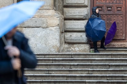 Una mujer se protege de la lluvia durante la manifestación del 8M, este sábado en Toledo.