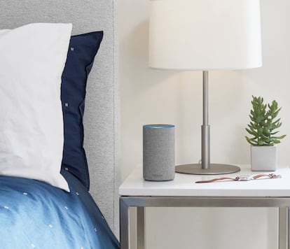 Un altavoz inteligente encima de una mesilla en un dormitorio.
