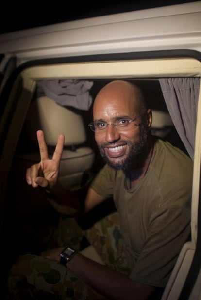 Saif al Islam hace el signo de la victoria a la salida del  hotel Rixos de Trípoli, la madrugada de ayer.