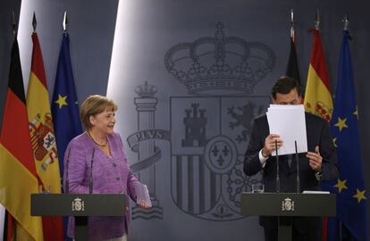Rajoy recoge sus notas al final de la rueda de prensa con Merkel.