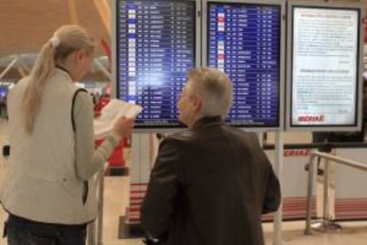 Dos personas consultan sus vuelos en el aeropuerto de Madrid-Barajas. EFE/Archivo