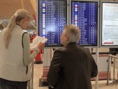 Dos personas consultan sus vuelos en el aeropuerto de Madrid-Barajas. EFE/Archivo