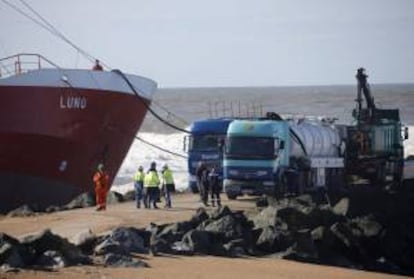 Varias personas realizan las labores de extracción de combustible en el carguero "Luno", en Anglet, el pasado viernes en el puerto de Bayona (Francia).