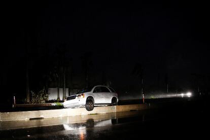 Un auto abandonado y atorado en un muro de contención, durante el paso del huracán, en Fort Myers.