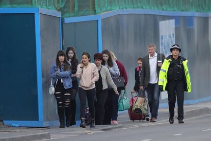 Asistentes al concierto de Ariana Grande abandonan el Hotel Park Inn donde fueron alojados tras la explosión el lunes por la noche en el Manchester Arena.