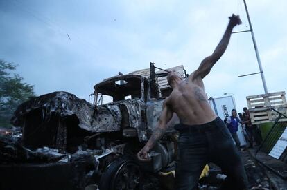 Manifestantes se enfrentan con miembros de la Policía Nacional Bolivariana, junto a un camión que transportaba ayuda humanitaria y fue quemado, este sábado, en el puente Francisco de Paula Santander, en la frontera entre Colombia y Venezuela.