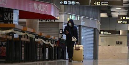 Un pasajero camina por el aeropuerto de Barajas, durante el estado de alarma, entre tiendas y bares cerrados. 