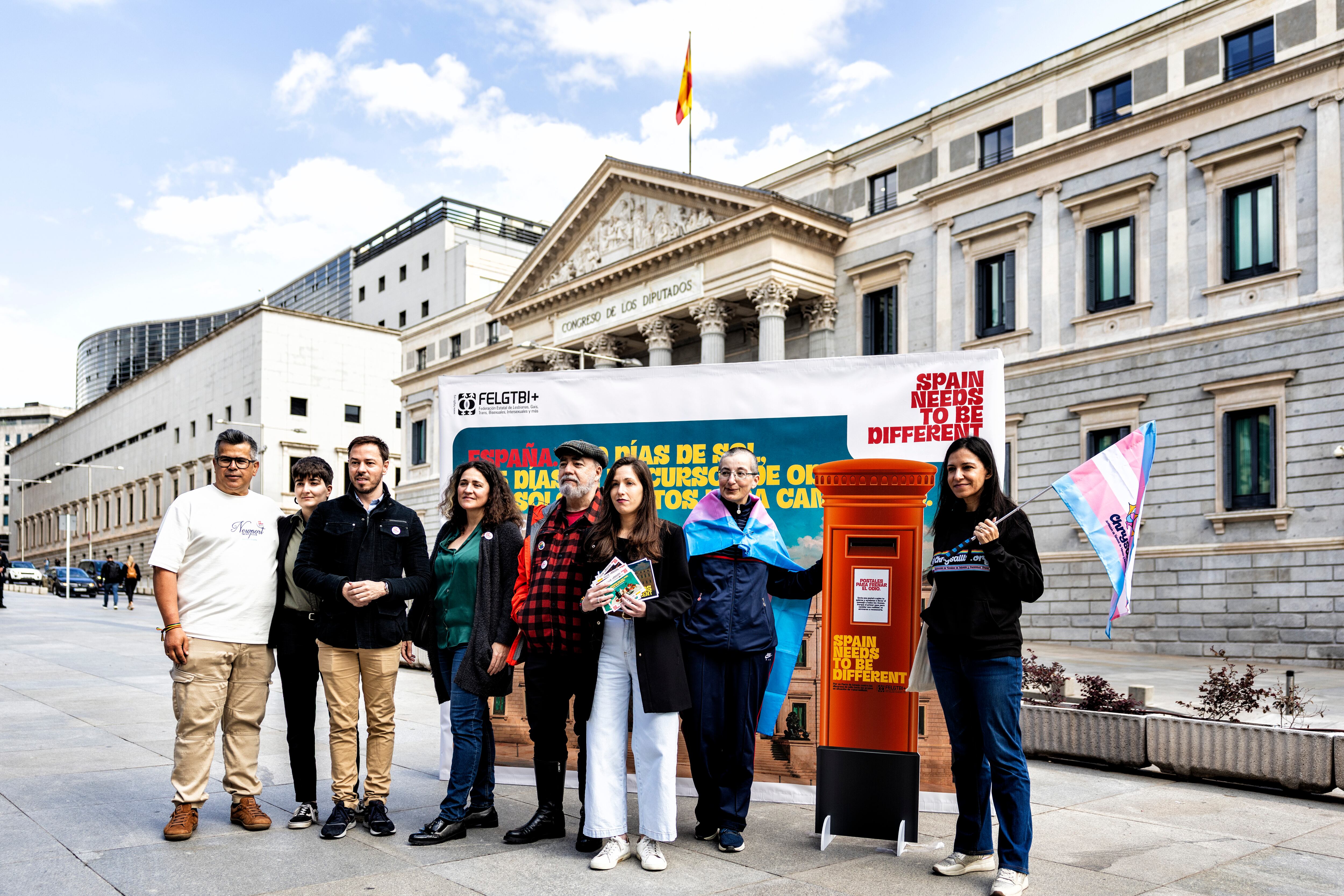 Activistas de la Felgtbi+ este martes con la pancarta que han llevado a la Cámara baja.