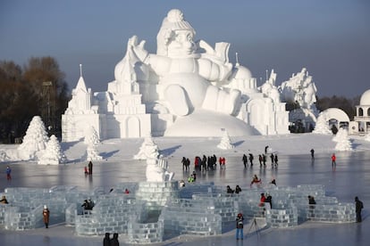 Varias personas visitan una escultura de nieve de 35 metros de alto en la trigésimo tercera edición del Festival Internacional de Hielo y Nieve de Harbin (China).