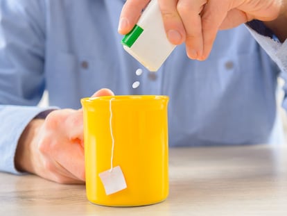 Un hombre echa sacarina en una infusión.