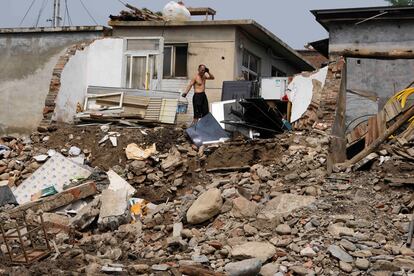 Un hombre recoge los escombros de lo que queda de su vivienda en Nanxinfang, este viernes.