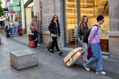 Turistas con maletas por la calle de Carretas de Madrid, en abril de 2023.