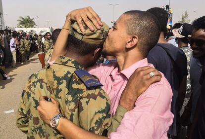 Un manifestante sudanés contra el régimen besa a un soldado en la cabeza durante las protestas, el 11 de abril de 2019, en la capital de Sudán, Jartum.