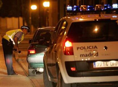 Un policía municipal habla de madrugada con un conductor en Villaverde.