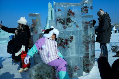 Un grupo de visitantes se fotografían con una escultura de hielo en el Festival Internacional de Esculturas y Hielo de la ciudad china el 6 de enero de 2025. 
