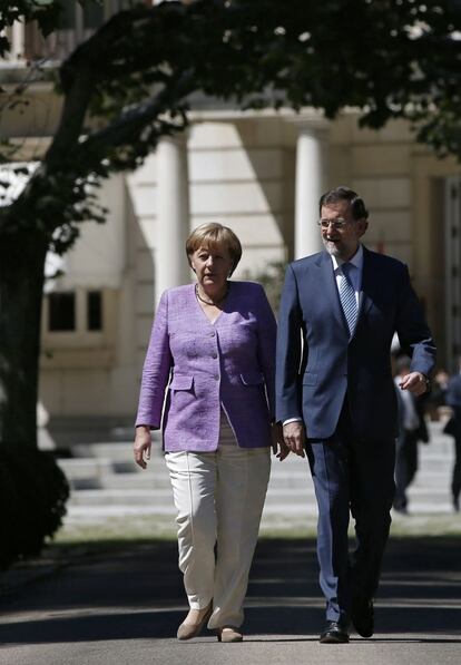 Merkel y Rajoy se dirigen hacia la rueda de prensa tras su entrevista en La Moncloa.
