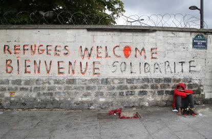 Un migrante aguarda cerca de un centro de recepci&oacute;n de migrantes en Par&iacute;s