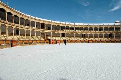 Un hombre y un niño, ayer, sobre la nieve acumulada en la plaza de toros de Ronda.