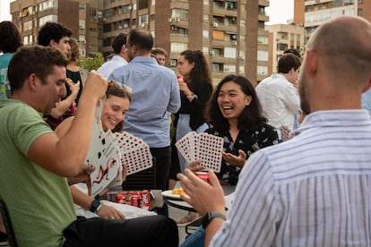 Empleados de la 'startup' alemana Celonis juegan a las cartas en la azotea de su oficina madrileña tras finalizar su jornada.