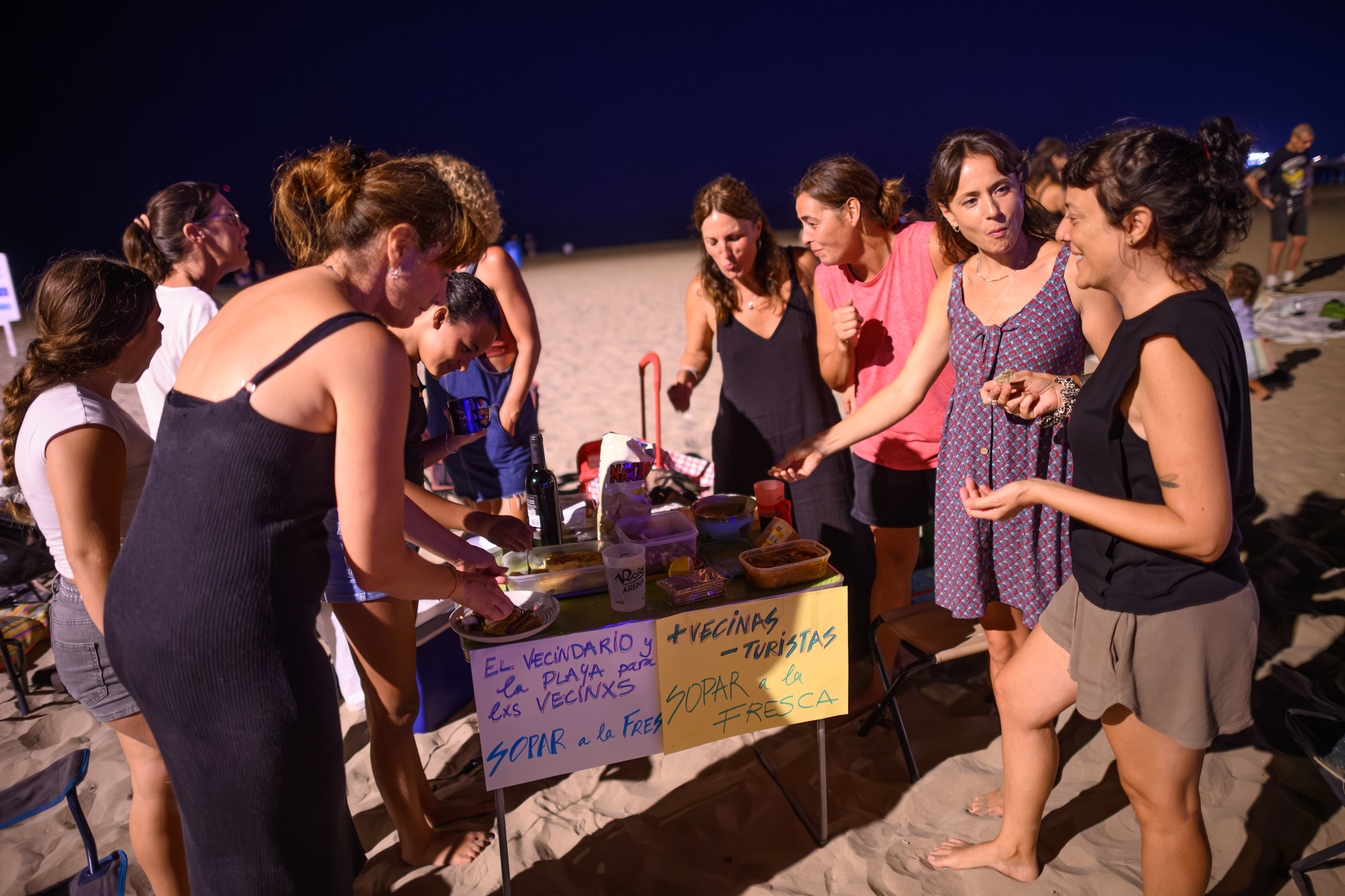 Varias vecinas comparten la comida que han traído durante el sopar a la fresca organizado el 5 de septiembre en Valencia.