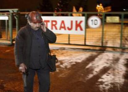Un minero pasa delante de un cartel en el que se puede leer "huelga", de camino a la mina de carbón "Pokoj", (Paz), en la localidad de Ruda Slaska, el sur de Polonia. EFE/Archivo