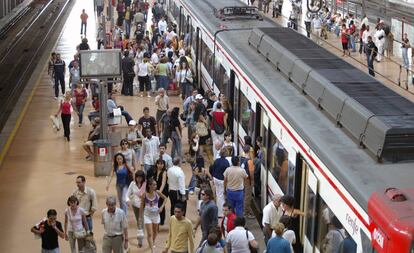 Decenas de viajeros junto a un tren de Cercan&iacute;as en los andenes de la estaci&oacute;n madrilela de Atocha.