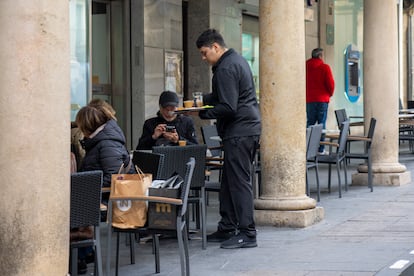 Un camarero sirve un café en la terraza de una cafetería en Teruel, este viernes