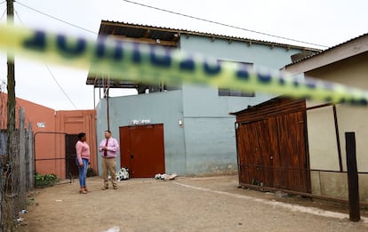 Vista de la entrada de la taberna Enyobeni, acordonada y con ramos de flores en la puerta, donde 21 adolescentes fallecieron por causas que aún se investigan.