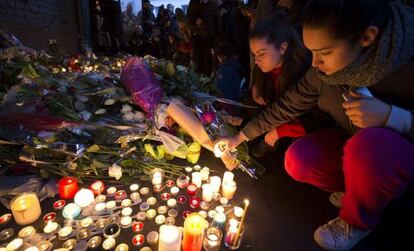 Un grupo de ciudadanos enciende velas en un altar improvisado en París para homenajear a las víctimas del atentado.