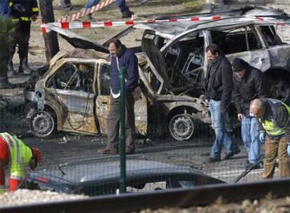 Policías y operarios de limpieza rastrean en las proximidades de donde estalló el coche bomba.