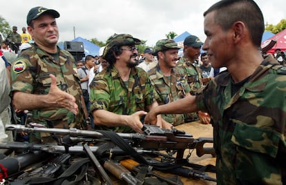 Un paramilitar del Bloque Banana que entrega su arma frente a Salvatore Mancuso, en una ceremonia de desarme cerca de Turbo (Antioquia), durante el proceso de desmovilización de las AUC, en noviembre de 2004.
