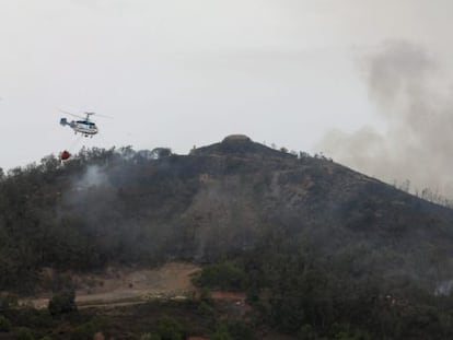 Un helicoptero durante las funciones de extinci&oacute;n del incendio forestal en Ceuta este lunes.