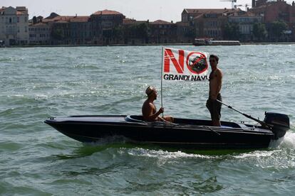 Dos personas viajan en un bote con una pancarta que dice 'No Grande Navi' durante una manifestación del movimiento 'No Big Ships' contra los grandes cruceros que navegan en la laguna de Venecia, el 8 de junio de 2019.