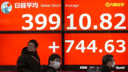 Varios peatones pasan ante un panel con las cotizaciones del Nikkei en Tokio, el pasado 1 de marzo.