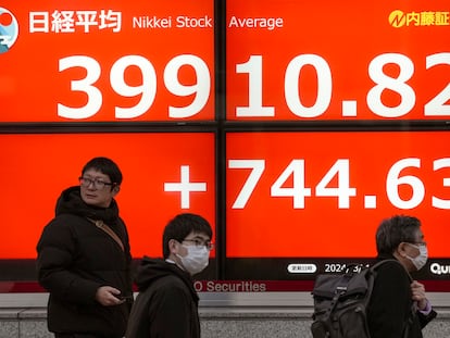 Varios peatones pasan ante un panel con las cotizaciones del Nikkei en Tokio, el pasado 1 de marzo.