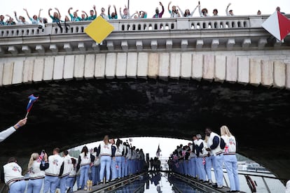 Un grupo de espectadores aplauden a los atletas británicos a su paso por uno de los puentes del río Sena.