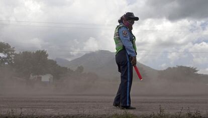 Una polic&iacute;a se protege ayer de la ceniza del volc&aacute;n.