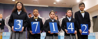 Los niños de San Ildefonso muestran el 37.142, agraciado con el primer premio del sorteo de la lotería de El Niño.