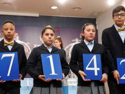 Los niños de San Ildefonso muestran el 37.142, agraciado con el primer premio del sorteo de la lotería de El Niño.