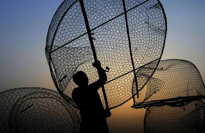 Un pescador carga su barco con trampas cerca de la costa del Golfo Pérsico, en una aldea al oeste de Malkiya (Baréin), 13 de mayo de 2013.